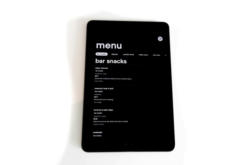 Tablet displaying a digital menu for bar snacks in a modern, minimalistic style.